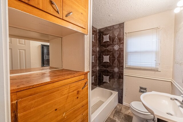 1204 Tinker St, Seagraves, TX 79359 - bathroom with a textured ceiling, a textured wall, bathtub / shower combination, toilet, and vanity