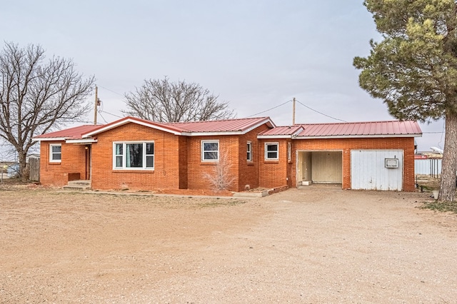 1204 Tinker St, Seagraves, TX 79359 - single story home featuring dirt driveway, metal roof, brick siding, and a garage