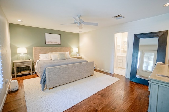 bedroom featuring ceiling fan, dark hardwood / wood-style flooring, and connected bathroom