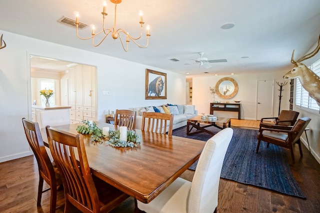 dining area featuring ceiling fan with notable chandelier and dark hardwood / wood-style flooring