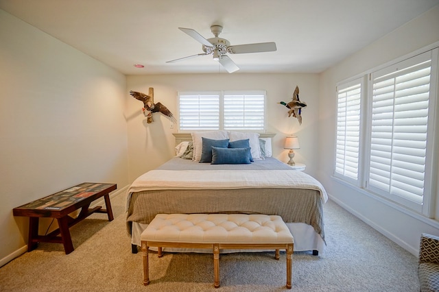 carpeted bedroom featuring multiple windows and ceiling fan