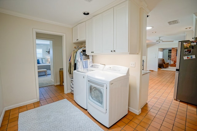 clothes washing area with cabinets, crown molding, ceiling fan, independent washer and dryer, and light tile patterned flooring