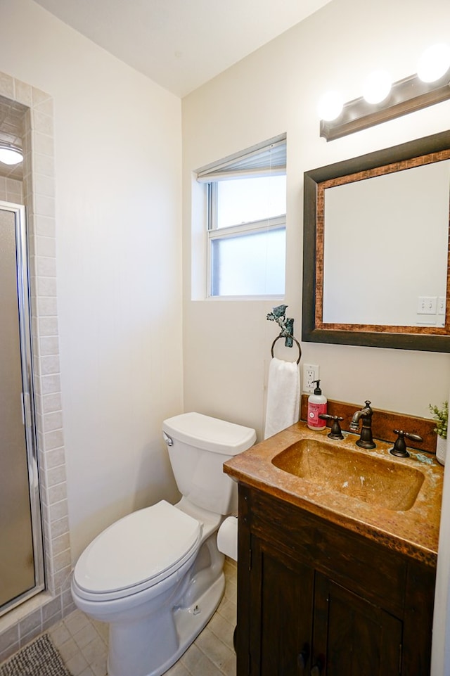 bathroom with tile patterned flooring, vanity, toilet, and a shower with door