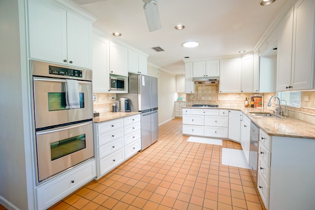 kitchen featuring appliances with stainless steel finishes, crown molding, sink, white cabinets, and range hood