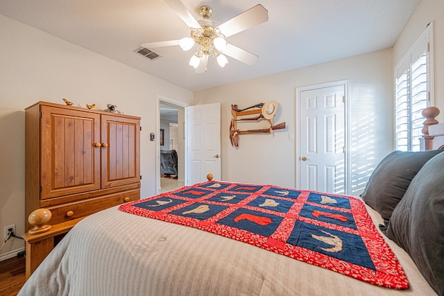 bedroom featuring ceiling fan, wood finished floors, and visible vents