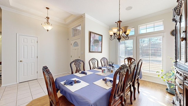 dining space with light tile patterned floors, baseboards, ornamental molding, and a notable chandelier