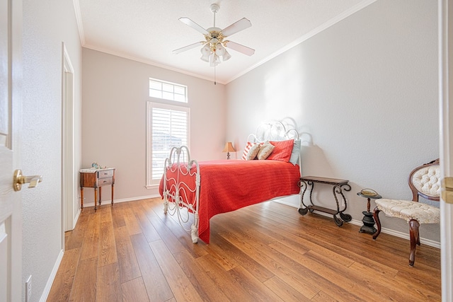 bedroom featuring light wood-style floors, crown molding, baseboards, and ceiling fan