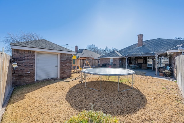 view of yard featuring a patio area, a fenced backyard, and a trampoline