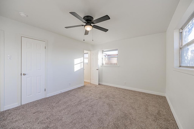 spare room with ceiling fan and carpet