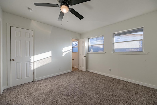 carpeted spare room featuring ceiling fan