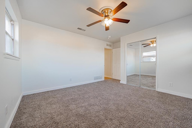 unfurnished bedroom with a closet, ceiling fan, and carpet flooring