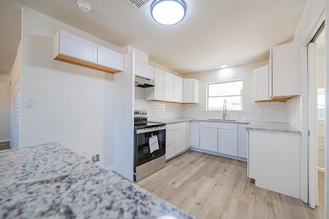 kitchen featuring sink, white cabinets, stainless steel range with electric cooktop, light hardwood / wood-style floors, and light stone countertops