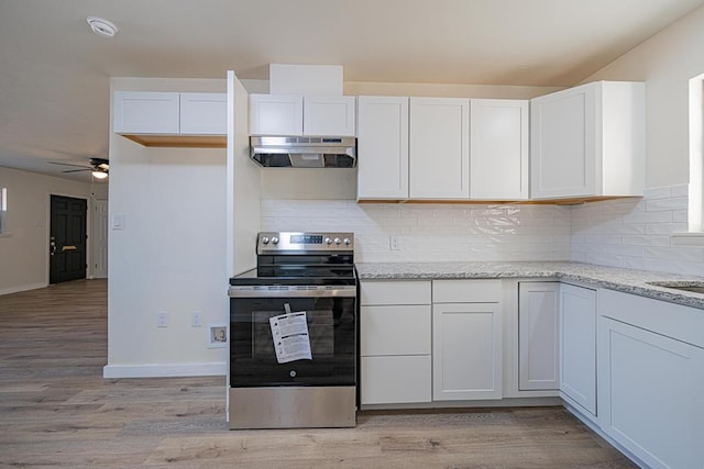 kitchen featuring ventilation hood, white cabinets, and electric range