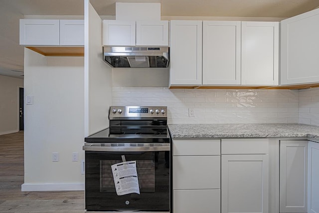 kitchen with backsplash, white cabinets, light stone countertops, light wood-type flooring, and stainless steel electric range