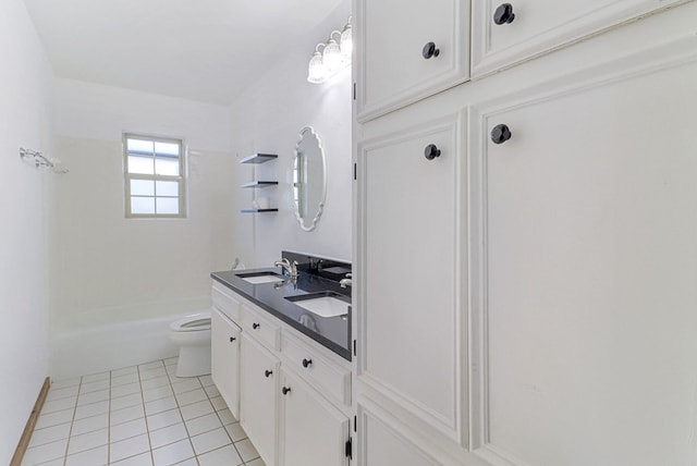 bathroom with tile patterned floors, double vanity, toilet, and a sink