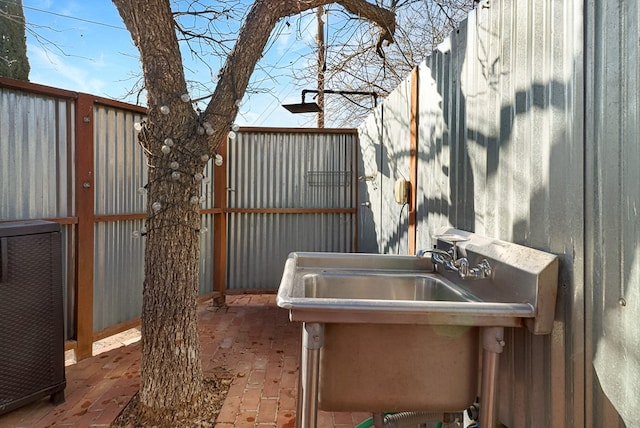 view of patio / terrace with fence and a sink