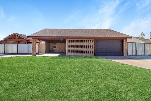 view of front of property with fence, an attached garage, a shingled roof, a front lawn, and concrete driveway