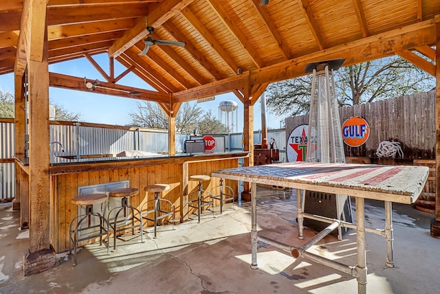 view of patio / terrace with a gazebo, outdoor dry bar, and fence