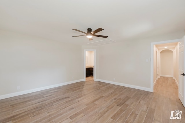 unfurnished room featuring baseboards, ceiling fan, attic access, and light wood-type flooring