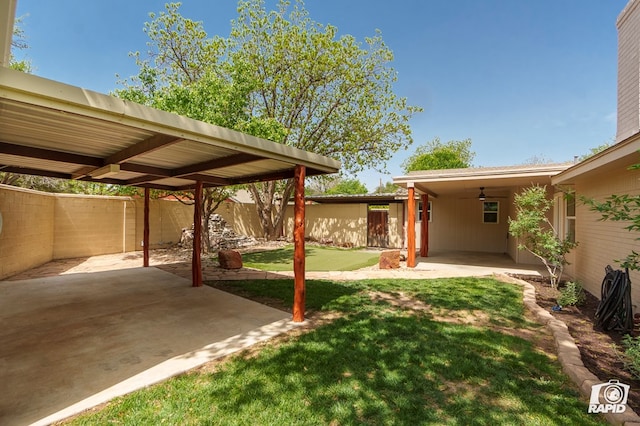 view of yard featuring a fenced backyard, a ceiling fan, and a patio area