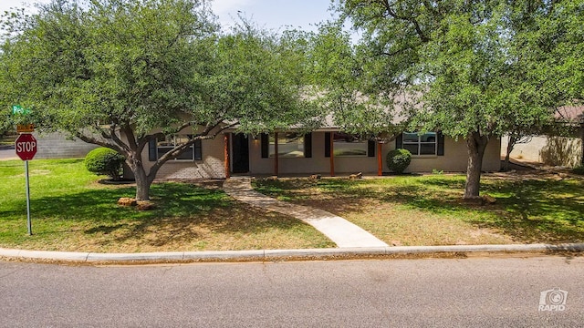 single story home featuring a front lawn and brick siding