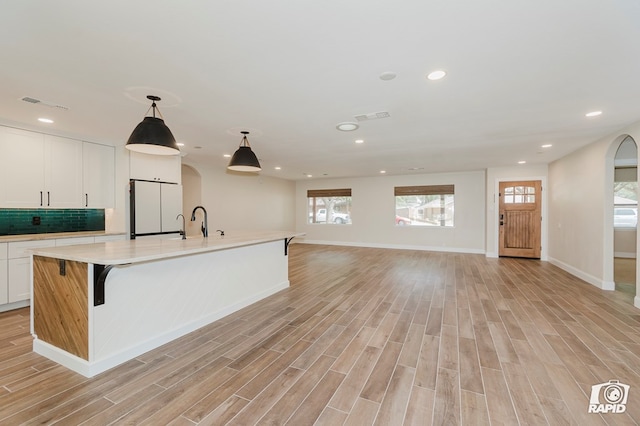 kitchen featuring light countertops, a healthy amount of sunlight, freestanding refrigerator, and visible vents