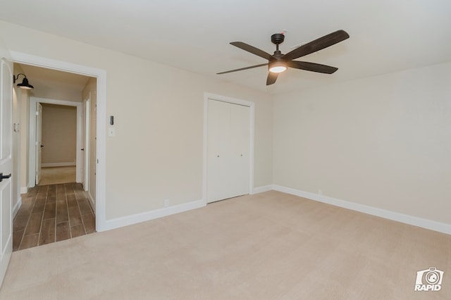 spare room featuring carpet floors, a ceiling fan, and baseboards