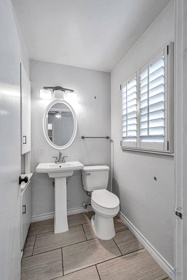 2008 Bedford Dr, Midland, TX 79701 - half bathroom featuring wood tiled floors, toilet, and baseboards