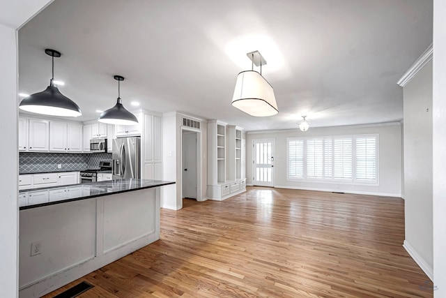 2008 Bedford Dr, Midland, TX 79701 - kitchen with appliances with stainless steel finishes, dark countertops, baseboards, white cabinetry, and light wood-style flooring
