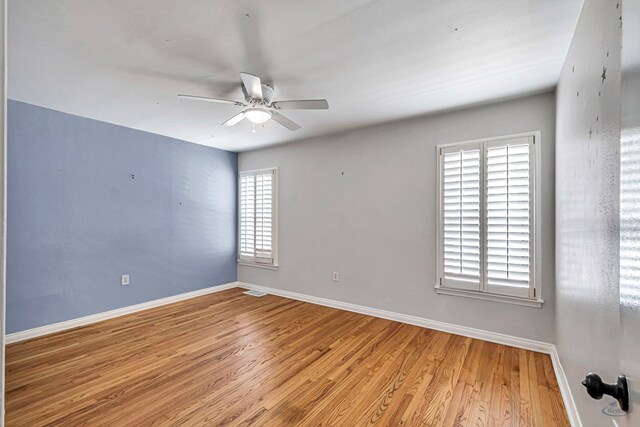 2008 Bedford Dr, Midland, TX 79701 - spare room featuring ceiling fan, plenty of natural light, wood finished floors, and baseboards