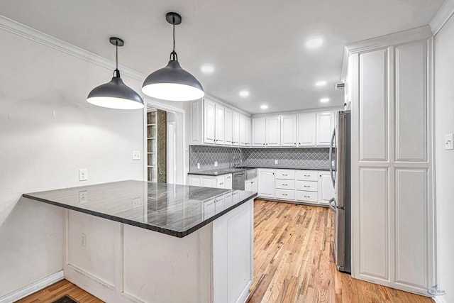 2008 Bedford Dr, Midland, TX 79701 - kitchen featuring a peninsula, stainless steel appliances, white cabinets, a kitchen breakfast bar, and tasteful backsplash