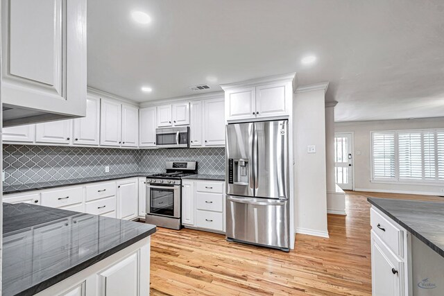 2008 Bedford Dr, Midland, TX 79701 - kitchen with stainless steel appliances, light wood-style flooring, white cabinets, decorative backsplash, and recessed lighting