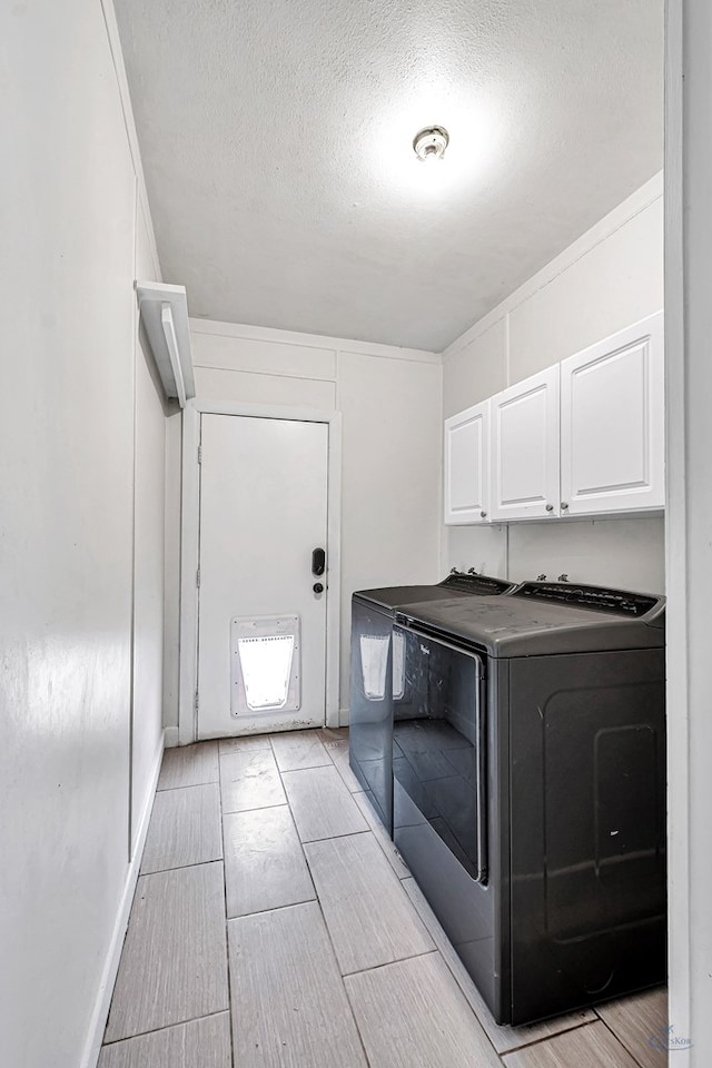 2008 Bedford Dr, Midland, TX 79701 - clothes washing area with cabinet space, separate washer and dryer, wood finish floors, and a textured ceiling