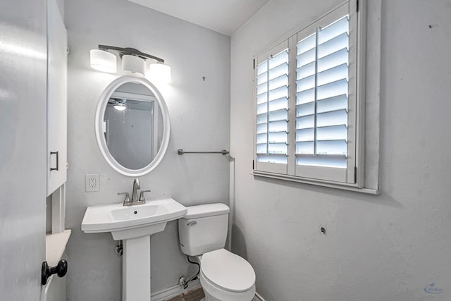 2008 Bedford Dr, Midland, TX 79701 - bathroom with plenty of natural light, toilet, a ceiling fan, and baseboards