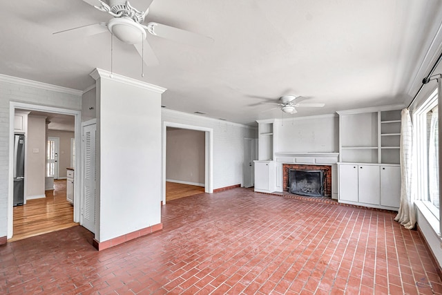 2008 Bedford Dr, Midland, TX 79701 - unfurnished living room with ceiling fan, brick flooring, a fireplace, ornamental molding, and baseboards