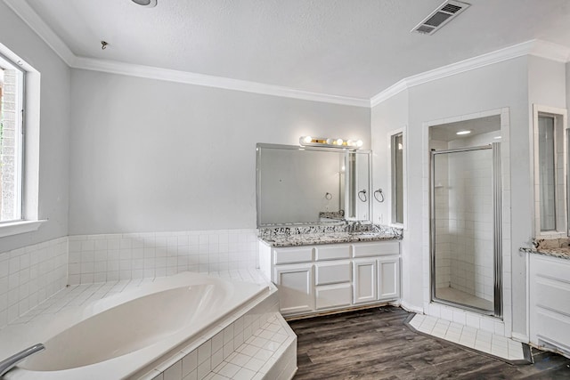 2008 Bedford Dr, Midland, TX 79701 - full bath featuring ornamental molding, a stall shower, vanity, a bath, and wood finished floors