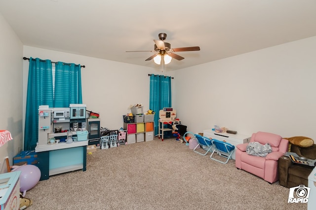 playroom with a ceiling fan and carpet flooring