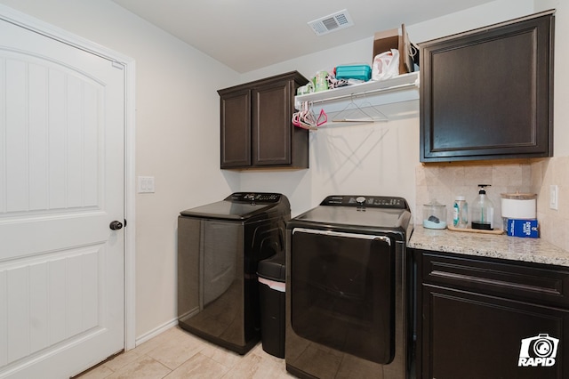 laundry area with cabinet space, visible vents, and washing machine and clothes dryer