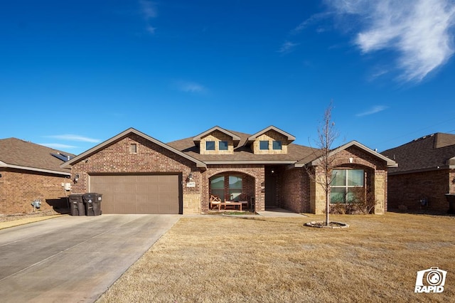 view of front facade with brick siding, roof with shingles, concrete driveway, an attached garage, and a front yard