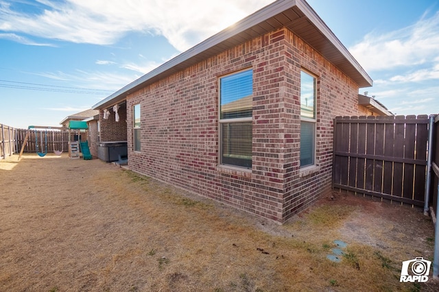 view of property exterior featuring brick siding and a fenced backyard