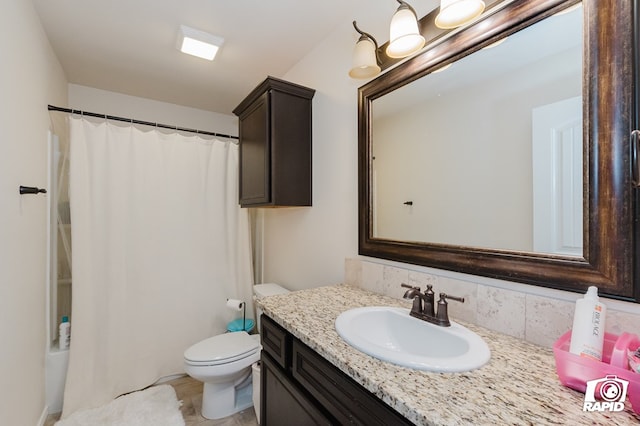 bathroom featuring curtained shower, vanity, and toilet