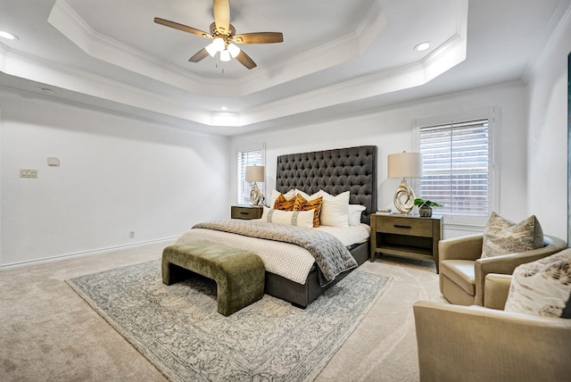 carpeted bedroom with ceiling fan, ornamental molding, and a tray ceiling