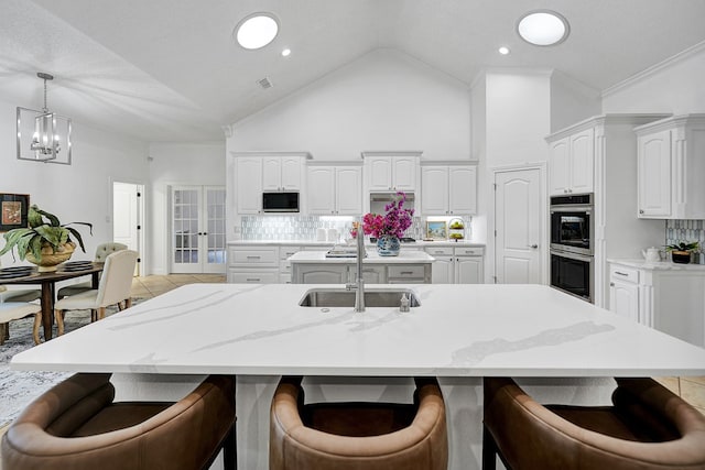 kitchen featuring white cabinets, a spacious island, and sink