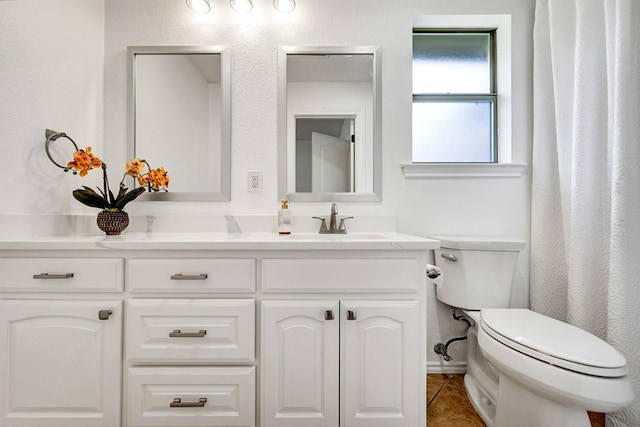 bathroom featuring tile patterned floors, vanity, and toilet