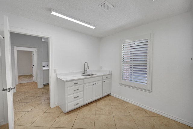 interior space featuring tile patterned floors, vanity, and a textured ceiling