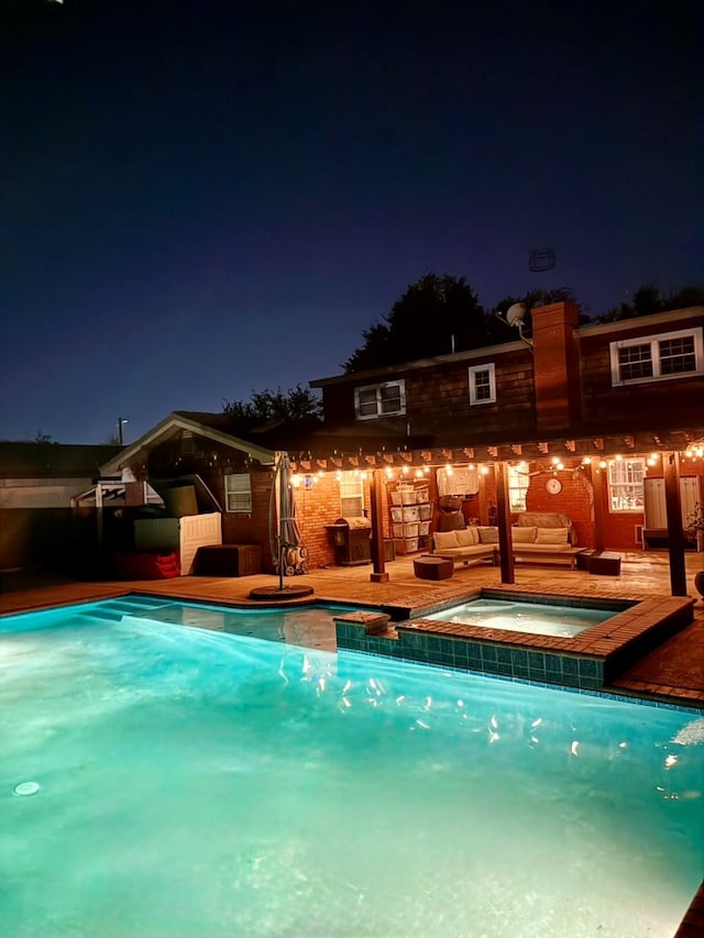 3302 Cord Dr, Midland, TX 79705 - pool at night with outdoor lounge area and a pool with connected hot tub