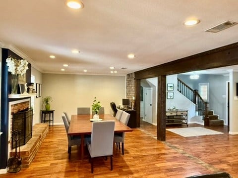 3302 Cord Dr, Midland, TX 79705 - dining room featuring a fireplace, recessed lighting, stairway, wood finished floors, and crown molding