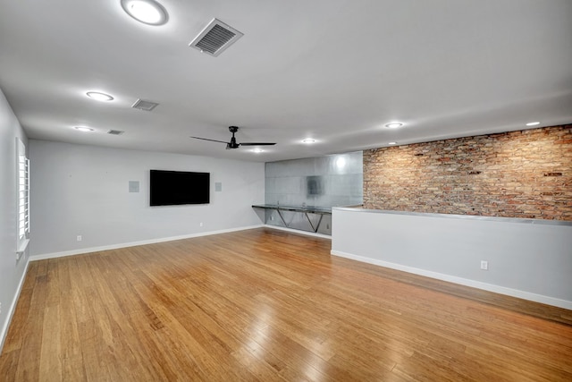 unfurnished living room featuring baseboards, a ceiling fan, light wood-style floors, and visible vents
