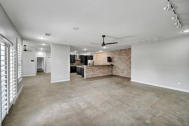 unfurnished living room featuring ceiling fan, baseboards, and rail lighting