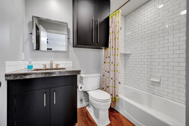 full bath with wood finished floors, shower / tub combo, toilet, and vanity